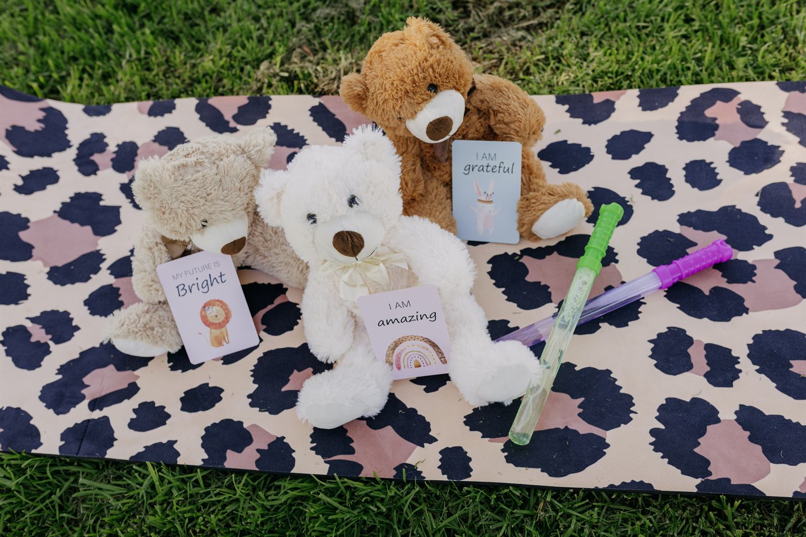 Teddy bears and affirmation cards arranged on a leopard-print mat