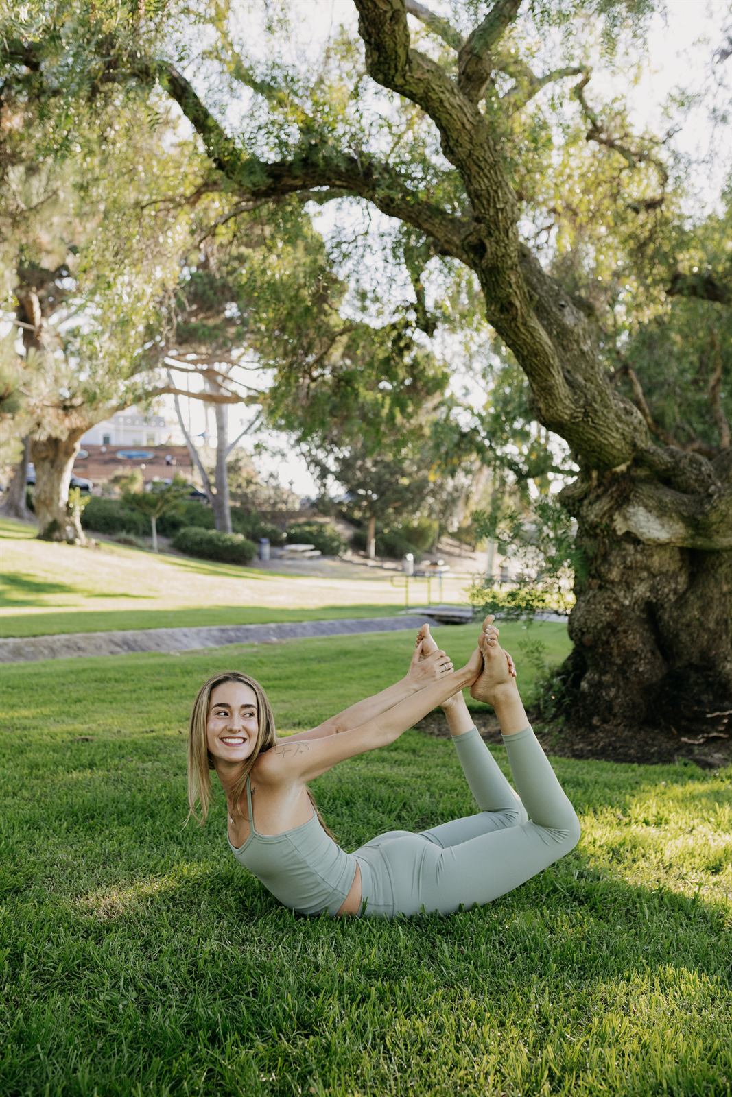 Teacher in a seated stretch on the grass